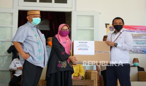 Koordinator Satuan Tugas (Satgas) BUMN untuk Penanganan COVID-19 di Provinsi Gorontalo, Teddy Indra Yudhana (kanan) disaksikan Gubernur Gorontalo Rusli Habibie (kiri) menyerahkan bantuan Alat Pelindung Diri (APB) kepada perwakilan Gugus Tugas COVID-19 Misranda Nalole (tengah) di rumah jabatan Gubernur di Kota Gorontalo, Gorontalo, Kamis (14/5/2020). Satgas BUMN di Gorontalo menyerahkan bantuan 1