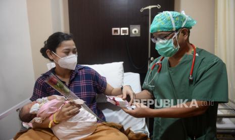 Dokter memberikan bunga dan kue kepada pasien yang baru melahirkan di RSIA Tambak, Jakarta, Selasa (22/12). Masih banyak ibu hamil yang ragu atau takut menjalani tes usap sebelum melahirkan. Ilustrasi. 