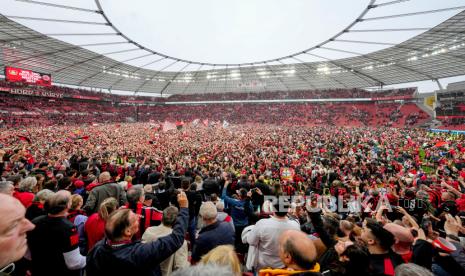 Ribuan suporter Leverkusen masuk kedalam lapangan setelah timnya memenangkan pertandingan sepak bola Bundesliga Jerman antara Bayer Leverkusen dan Werder Bremen di Leverkusen, Jerman, Ahad (14/4/2024). Bayer Leverkusen memastikan gelar juara Bundesliga 2023/2024 usai mengalahkan Werder Bremen dengan skor telak 5-0. Kemenangan ini sontak dirayakan puluhan ribu pendukung setianya yang memadati Stadion BayArena. Para pendukung tumpah ruah di tengah lapangan merayakan kesuksesan tim kesayangannya.