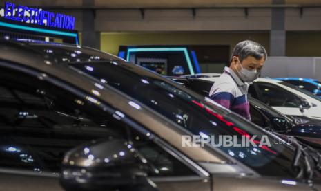 Pengunjung mengamati mobil yang dipamerkan dalam pameran mobil.