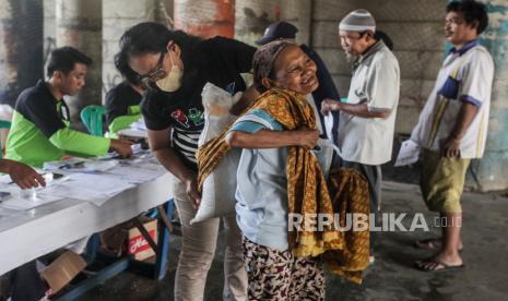 Petugas membantu warga memanggul karung beras saat penyaluran Bantuan Sosial (Bansos) Cadangan Beras Pemerintah (CBP) di kawasan Warakas, Tanjung Priok, Jakarta Utara, Selasa (20/2/2024). Sebanyak 1.000 karung cadangan beras pemerintah disalurkan kepada warga di kelurahan Warakas untuk meringankan beban masyarakat dalam memenuhi kebutuhan konsumsinya ditengah kenaikan harga beras.