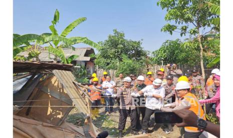 Kapolres Indramayu AKBP M Fahri Siregar (kanan) ikut merobohkan rutilahu warga di Desa Rajasinga, Kecamatan Terisi, Kabupaten Indramayu, Rabu (9/8/2023), untuk kemudian dilakukan pembangunan.