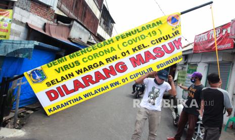 Warga melintas di depan pintu masuk yang melakukan karantina wilayah Di Cipulir, Jakarta Selatan, Rabu (8/4/2020). Karantina wilayah tersebut dilakukan oleh warga guna mencegah penyebaran Virus Corona (COVID-19) serta membantu Pemrov DKI dalam menerapkan status Pembatasan Sosial Bersekala Besar (PSBB)