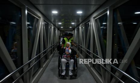 Calon jamaah haji kloter pertama dibantu petugas saat akan menaiki pesawat di Bandara Soekarno Hatta, Tangerang, Banten, Ahad (12/5/2024) dini hari. Sebanyak 8.700 orang jamaah haji gelombang pertama dari 22 kloter akan diterbangkan ke Madinah untuk melaksanakan ibadah haji. Pada kesempatannya Menag RI Yaqut Cholil Qoumas ikut melepas keberangkatan jamaah haji di Bandara Soekarno Hatta. Selain itu, Gus Men, sapaan akrab Yaqut Cholil Qoumas mengapresiasi layanan fast track yang difasilitasi Pemerintah Arab Saudi dalam memudahkan jamaah sehingga proses pemeriksaan dokumen jamaah haji oleh keimigrasian Pemerintah Arab Saudi dapat dlakukan di bandara Soekarno Hatta sebagai upaya untuk menghemat proses keimigrasian jamaah saat tiba di Bandara tujuan. Untuk diketahui, Jumlah jamaah haji lansia tahun 2024 ini sebanyak 41.000 orang.