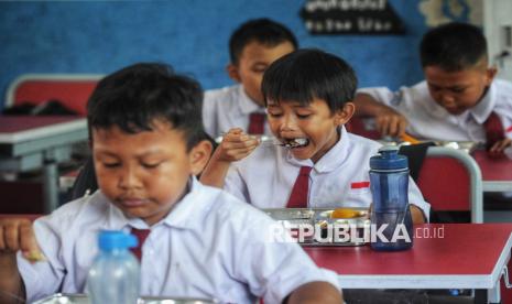 Para siswa menyantap hidangan Makan Bergizi Gratis (MBG) di SDN 05 Sukatani, Depok, Jawa Barat, Senin (6/1/2025). 