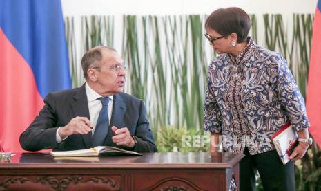   Menlu Rusia Sergei Lavrov (kiri) berbicara dengan Menlu Indonesia Retno Marsudi setibanya untuk pertemuan trilateral antara Indonesia, Rusia dan China.