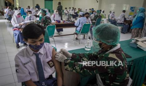 Petugas medis dari TNI menyuntikan vaksin kepada pelajar saat Vaksinasi COVID-19 di SMA Negeri 1 Surakarta, Solo, Jawa Tengah, Kamis (5/8/2021). Pemkot Solo menargetkan 70 ribu pelajar SMP hingga SMA usia 12-17 tahun menjadi sasaran program vaksinasi COVID-19 untuk meningkatkan kesiapan menghadapi pembelajaran tatap muka saat sekolah sudah kembali dibuka. 