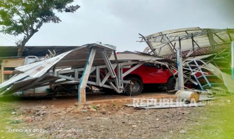 Satu unit mobil tertimpa material saat hujan turun disertai angin kecenang.