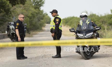  Petugas polisi San Antonio menjaga tempat kejadian Selasa, 28 Juni 2022, di San Antonio di mana puluhan migran ditemukan tewas di sebuah trailer-traktor pada hari Senin setelah ditinggalkan dalam panas terik. Ini adalah tragedi terbaru yang merenggut nyawa para migran yang diselundupkan melintasi perbatasan dari Meksiko ke AS.