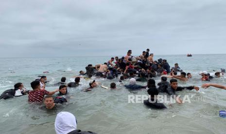 Para migran berhasil mengambil perahu otoritas Maroko di dekat pantai Fnideq (Maroko) dalam upaya untuk menyeberang ke Ceuta, kantong Spanyol di Afrika utara, Selasa (18/5),  ketika pasukan tentara Spanyol dikerahkan setelah total 5.000 orang Maroko warga negara berhasil memasuki kota melalui laut pada malam hari dan ratusan migran terus berdatangan.