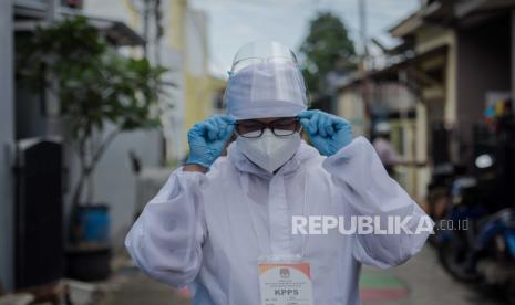 Petugas Kelompok Penyelenggara Pemungutan Suara (KPPS) menggunakan pakaian alat pelindung diri (APD) saat memberikan pelayanan jemput bola kepada warga yang sakit di kawasan Depok, Jawa Barat, Rabu (9/12). Pelayanan jemput bola tersebut dilakukan guna memenuhi hak pilih warga yang sakit dan terkena COVID-19 pada Pilkada 2020. Republika/Thoudy Badai