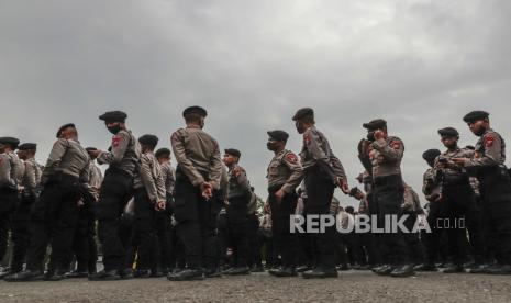 Petugas kepolisian berkumpul saat kunjungan presiden Indonesia di Stadion Kanjuruhan di Malang, Jawa Timur, Indonesia, 05 Oktober 2022. Presiden Indonesia telah memerintahkan penyelidikan dan audit ke semua stadion sepak bola di tanah air, untuk memastikan keselamatan penggemar setelah di Sedikitnya 131 orang tewas dalam kerusuhan dan penyerbuan menyusul pertandingan sepak bola antara Arema FC dan Persebaya Surabaya di Jawa Timur pada 01 Oktober 2022.