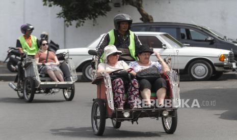 Wisatawan menaiki becak di Alun-alun Kidul, Yogyakarta, Rabu, (19/10/2022). Data dari Pemerintah Kota Yogyakarta menyebutkan berdasarkan survei jumlah kunjungan wisatawan ke Yogyakarta mencapai 5,1 juta orang dan sudah melampaui target kunjungan wisatawan yang ditetapkan Pemkot Yogyakarta pada tahun 2022 yakni sekitar 2 juta orang. 