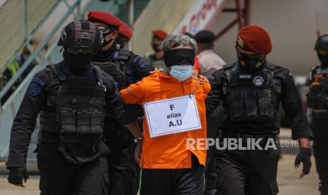 Personel Densus 88 Anti Teror membawa terduga teroris menuju mobil tahanan setibanya di Bandara Internasional Soekarno Hatta, Tangerang, Banten, Kamis (18/3/2021). Sebanyak 22 tahanan kasus terorisme jaringan Jamaah Islamiyah (JI) dari Jawa Timur tiba di Bandara Soekarno Hatta dan selanjutnya dibawa ke Rutan Cikeas, Bogor, Jawa Barat. 