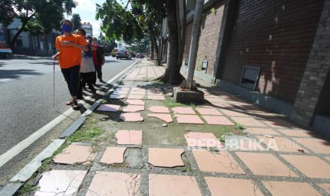 Sejumlah tuna netra berjalan beriringan di bahu jalan, (ilustrasi). Lazismu bersama Bank Bukopin Syariah menyalurkan bantuan untuk para disabilitas netra terdampak Covid-19.