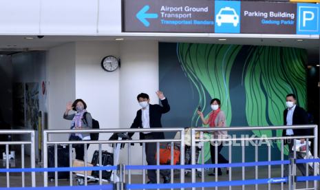 Sejumlah penumpang pesawat maskapai penerbangan Garuda Indonesia dengan nomor penerbangan GA881 tiba di Bandara Internasional I Gusti Ngurah Rai, Badung, Bali, Kamis (3/2/2022). Penerbangan dengan rute Narita, Jepang menuju Bali yang mengangkut 12 orang penumpang tersebut menjadi penerbangan komersial rute internasional perdana yang dilayani Bandara I Gusti Ngurah Rai setelah pintu masuk internasional di bandara tersebut ditutup akibat pandemi COVID-19. 