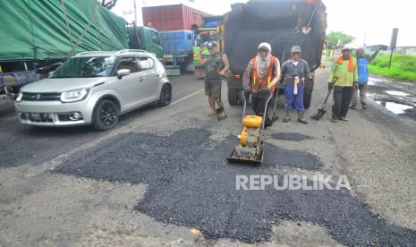 Pekerja melakukan proses perbaikan jalan di jalan jalur pantura wilayah Jawa Tengah (ilustrasi) 