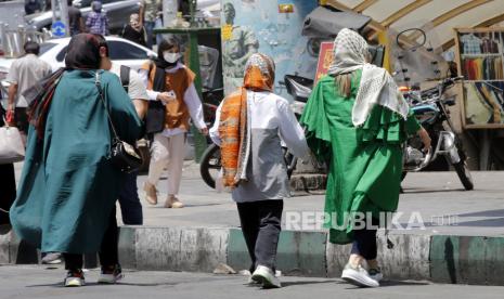 Wanita Iran berjalan di jalan Teheran, Iran. Polisi Iran mulai memperingatkan wanita tentang aturan berpakaian dan gaya rambut mereka di sebagian besar kota terutama di ibu kota Teheran. Polisi Iran telah beberapa kali memperingatkan untuk menghadapi wanita berpakaian 