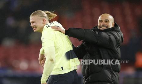  Pelatih kepala Manchester City Pep Guardiola (kanan) dan penyerang Erling Haaland.