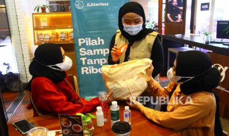 Pegiat lingkungan menjelaskan tipe sampah plastik daur ulang kepada pengunjung saat peringatan Hari Konsumen Peduli Lingkungan Sedunia di sebuah kafe di Malang, Jawa Timur, Selasa (28/9/2021). 