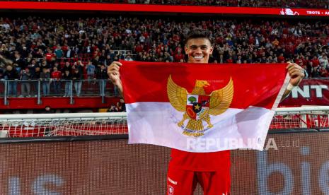 Pemain FC Twente Mees Hilgers memegang bendera Indonesia seusai laga melawan Heerenveen Selasa (17/9/2024).