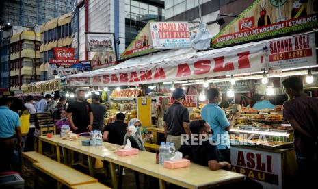 Warga menunggu waktu berbuka puasa di sentra kuliner nasi kapau, Jalan Kramat Raya, Senen, Jakarta Pusat, selasa (12/4/2022). Sentra kuliner nasi kapau menjadi salah satu alternatif destinasi kuliner untuk berbuka puasa bersama dengan sajian makanan khas Sumatera Barat. Republika/Thoudy Badai