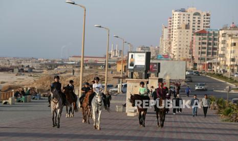 Saling Berbagi Keceriaan Ramadhan di Gaza Palestina. Foto: Seorang bocah Palestina mengendarai kuda di sepanjang pantai menunggu waktu berbuka puasa saat Ramadhan di Jalur Gaza, Palestina.