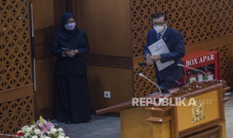 Menteri Hukum dan HAM Yasonna Laoly (kanan) bersiap menyampaikan tanggapan pemerintah pada rapat paripurna DPR Ke-10 masa Persidangan II Tahun Sidang 2021-2022 di Kompleks Parlemen, Senayan, Jakarta, Selasa (7/12). Revisi UU Kejaksaan yang sudah disahkan menjadi undang-undang tersebut diklaim mengatur independensi penuntutan.