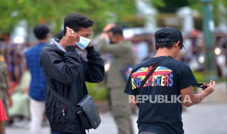 Wisatawan memakai masker usai ditegur Satgas Covid-19 Yogyakarta di kawasan Titik Nol Yogyakarta, Rabu (9/2/2022). Ketua Satuan Tugas Covid-19 Ikatan Dokter Indonesia (IDI) Zubairi Djoerban mengingatkan Covid-19 varian omicron mudah menular hingga 20 kali lebih cepat dibandingkan Covid-19 varian delta. 