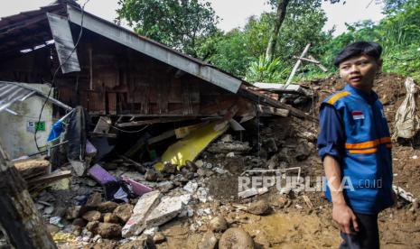 Relawan berdiri di dekat rumah yang terdampak longsor di Kampung Lebak Kantin, Sempur, Kota Bogor, Jawa Barat, Senin (25/3/2024). 