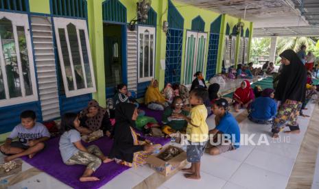 Sejumlah warga korban banjir menyantap bantuan nasi bungkus di teras Masjid Al-Anshar di Desa Pakuli Utara, Gumbasa, Sigi, Sulawesi Tengah, Selasa (6/9/2022). Sedikitnya 60 kepala keluarga terpaksa mengungsi ke masjid tersebut karena rumahnya rusak dan digenangi air akibat banjir yang menerjang desa itu pada Selasa (6/9) dini hari. 