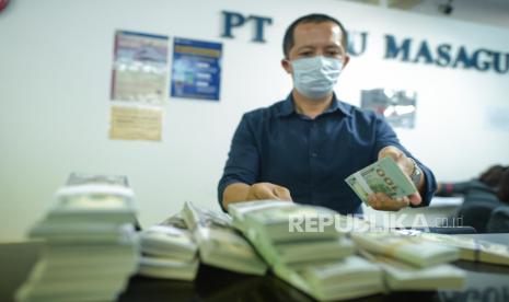 Petugas menghitung uang dollar AS di salah satu gerai penukaran uang asing di Jakarta, Kamis (19/3).(Thoudy Badai/Republika)