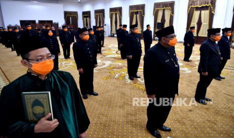 Sejumlah Aparatur Sipil Negara (ASN) eselon III dan IV mengikuti pengambilan sumpah jabatan di Gedung Negara Grahadi, Surabaya, Jawa Timur, Jumat (27/3/2020). Pengambilan sumpah tersebut dilaksanakan dengan mengenakan masker dan setiap peserta berjarak satu meter untuk mengantisipasi penyebaran Virus Corona (COVID-19)