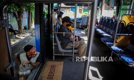 Seorang pedagang menawarkan dagangannya kepada penumpang bus Damri yang menunggu keberangkatan di Terminal Leuwipanjang, Bandung, Jawa Barat, Rabu (3/6). Operator angkutan penumpang milik pemerintah, Perum Damri, berkolaborasi dengan pihak swasta, yakni Shopeepay untuk layanan pembayaran digital dalam pemesanan atau pembelian tiket Damri.