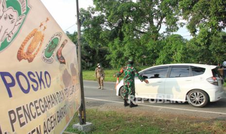 Petugas memeriksa pengendara yang memasuki wilayah Kabupaten Aceh Barat di jalan perbatasan Kabupaten Nagan Raya dan Kabupaten Aceh Barat, Kecamatan Meureubo, Aceh, Jumat (10/4/2020). Pemerintah Kabupaten Aceh Barat memperketat pemeriksaan kesehatan dan pendataan kependudukan di jalur masuk kabupaten sebagai upaya mencegah lebih dini penyebaran COVID-19