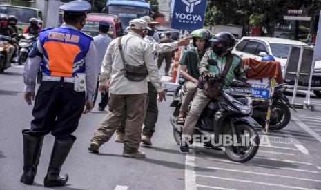 Petugas gabungan menghentikan pengendara yang tidak menggunakan masker saat operasi gabungan patroli pengawasan dan penegakan disiplin protokol kesehatan Covid-19 di Jalan Dalem Kaum, Kota Bandung, Kamis (31/12). Pemerintah Kota Bandung bersama petugas gabungan TNI, Polri, Satpol PP, Dishub dan aparat kewilayahan memperketat kendaraan dan melakukan razia protokol kesehatan guna mengantisipasi serta meminimalisir penyebaran Covid-19 jelang liburan tahun baru 2021. Foto: Abdan Syakura/Republika