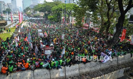 Sejumlah pengemudi ojek online (ojol) melakukan aksi unjuk rasa kawasan Patung Kuda, Jakarta, Kamis (29/8/2024). Mereka menuntut pemerintah dan perusahaan transportasi online untuk melegalkan status profesi driver ojol dalam undang-undang (UU). Selain itu, mereka juga menuntut perusahaan aplikasi untuk menurunkan biaya potongan aplikasi. Mereka datang dengan menggunakan atribut perusahaan masing-masing seperti Gojek, Grab, Shopee, dan Maxim.