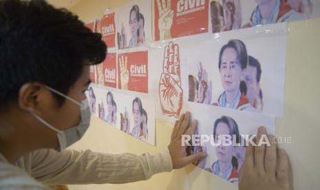 Seorang pengunjuk rasa anti-kudeta melihat gambar pemimpin Myanmar yang digulingkan Aung San Suu Kyi selama protes terhadap kudeta militer di Yangon, Myanmar, pada hari Senin, 26 April 2021.