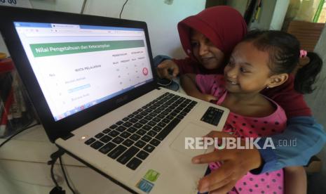 Kemenag Siapkan Empat Skema PJJ Madrasah. Orang tua bersama anaknya memantau rapor digital semester satu Madrasah Ibtidaiyah Negeri 2 Kediri di rumahnya,  di Kota Kediri, Jawa Timur, Rabu (23/12/2020). Aplikasi raport digital berbasis Nomor Induk Siswa Nasional (NISN) tersebut dapat diakses oleh orang tua siswa tanpa harus mengambil rapor ke sekola guna mengantisipasi penyebaran COVID-19. 