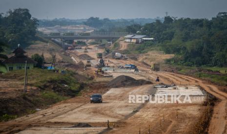 Pekerja menggunakan alat berat beraktivitas di proyek pembangunan jalan Tol Rangkasbitung-Cileles di Cikulur, Kabupaten Lebak, Provinsi Banten, Kamis (7/7/2022). 