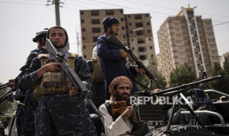  Pejuang Taliban mengawal wanita berbaris mendukung pemerintah Taliban di luar Universitas Kabul, Afghanistan, pada Sabtu, 11 September 2021.