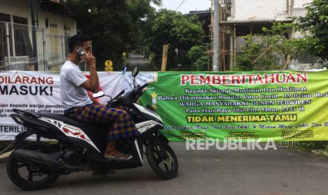 Warga berada di pintu masuk kampung yang ditutup di Terwilen, Margodadi, Seyegan, Sleman, Daerah Istimewa Yogyakarta (DIY), Selasa (26/5/2020). Sekretaris Daerah Istimewa Yogyakarta (DIY) Kadarmanta Baskara Aji menyebut DIY siap menerapkan skenario normal baru.