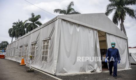 Petugas kesehatan berjalan di depan Posko Covid-19 RSUD Al-Ihsan, Baleendah, Kabupaten Bandung, Kamis (30/12). Juru Bicara Pemerintah Penanganan Covid-19 Wiku Adisasmito menyebut, pelaksanaan PPKM level di tingkat makro saat ini masih belum berjalan dengan baik. Hal itu terlihat dari kinerja posko yang konsisten terus menurun ke level sangat rendah.