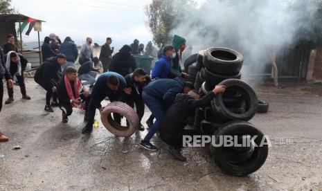 Bentrokan di Tepi Barat, Warga Palestina Pertahankan Desa dari Israel. Warga Palestina bentrok dengan tentara Israel di desa Burqa dekat kota Nablus, Tepi Barat, 23 Desember 2021. Bentrokan meletus setelah pemukim Israel tiba untuk memprotes di dekat desa tempat seorang pemukim dibunuh pekan lalu oleh warga Palestina.