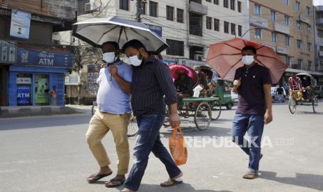 Sejumlah warga menggunakan payung untuk melindungi diri dari gelombang panas di Dhaka, Bangladesh