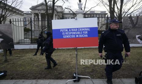 Petugas polisi berjaga saat spanduk berwarna bendera Rusia dipasang di Kedutaan Besar Rusia saat demonstrasi anti-perang di Warsawa, Polandia, Rabu, 6 April 2022. Kantor berita Rusia, RIA mengutip Deputi Menteri Luar Negeri Alexander Grushko yang mengatakan Rusia tidak berencana dengan proaktif menutup kedutaan-kedutaannya di Eropa.