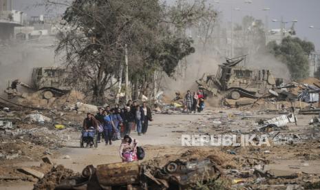 Warga Palestina melarikan diri ke selatan pada hari ketiga gencatan senjata antara Israel dan Hamas di jalan Salah al-Din di Jalur Gaza tengah pada  Ahad (26/11/2023). 