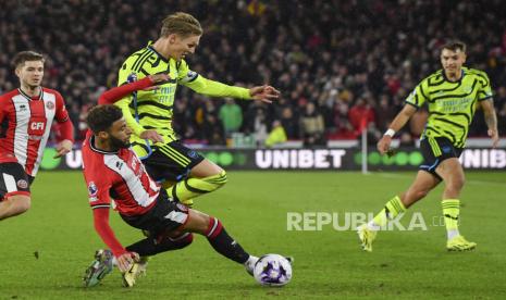 Pemain Arsenal Martin Odegaard berebut bola dengan pemain Sheffield United Jayden Bogle saat pertandingan sepak bola Liga Premier Inggris di stadion Bramall Lane, Sheffield, Selasa (5/3/2024). Arsenal menang telak atas Sheffield dengan skor 6-0. Gol-gol Arsenal tercipta lewat Martin Odegard di menit ke-5, gol bunuh diri Jayden Bogle menit ke-13, Gabriel Martinelli menit 15, Kai Havertz menit 25, Declan Rice menit 39 dan Ben White di menit ke-58. Berkat kemenangan ini, Arsenal berada di posisi ketiga klasemen dengan raihan 61 poin dari 27 pertandingan.