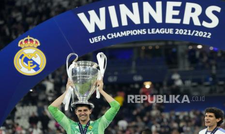  Penjaga gawang Real Madrid Thibaut Courtois berpose dengan trofi setelah memenangkan pertandingan sepak bola final Liga Champions antara Liverpool dan Real Madrid di Stade de France di Saint Denis dekat Paris,  Ahad (29/5/2022) dini hari WIB.