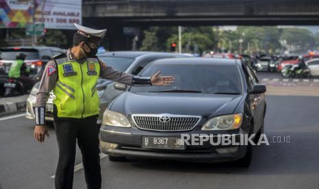 Anggota kepolisian menghentikan kendaraan di kawasan Fatmawati, Jakarta, Senin (10/8). Direktorat Lalu Lintas Polda Metro Jaya kembali menerapkan sanksi tilang terhadap kendaraan roda empat yang melanggar peraturan ganjil genap di masa Pembatasan Sosial Berskala Besar (PSBB) transisi. Republika/Putra M. Akbar